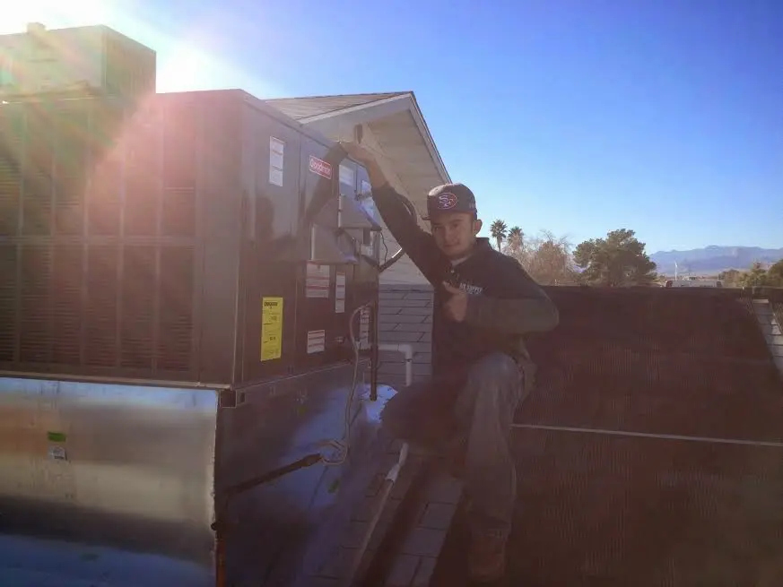 HVAC technician performing AC Tune-Up on a rooftop unit in Mountain Brook